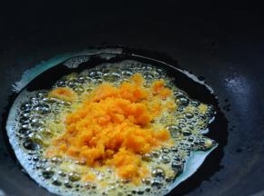 锅里倒入适量的菜籽油，倒入蛋黄翻炒至冒气泡。