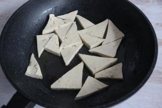 平底锅倒入适量食用油，比平时炒菜多一倍就可以。放入豆腐块，中火煎制。