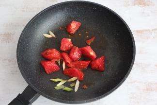 锅内留底油，先煸香葱花，放入西红柿翻炒。