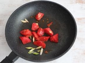 锅内留底油，先煸香葱花，放入西红柿翻炒。