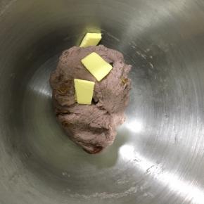 揉到面团有点粘手但是不会粘上面团的时候，加入软化的黄油，继续揉