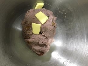 揉到面团有点粘手但是不会粘上面团的时候，加入软化的黄油，继续揉