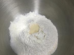 全麦粉与高筋面粉混合，盐和糖对角线放置，中间戳一孔，倒入活性干酵母