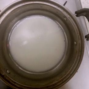 3.将80克牛奶倒入奶锅中，小火加热至表面冒泡，一定要小火！