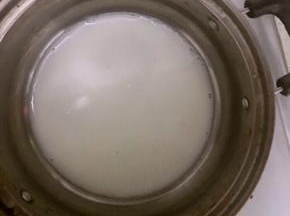 3.将80克牛奶倒入奶锅中，小火加热至表面冒泡，一定要小火！