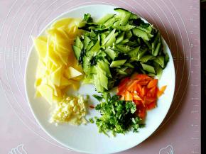 把黄瓜，胡萝卜和土豆分别切成菱形块儿，大蒜切末，香菜切段儿。