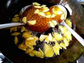 锅中热油，在油温达到五六成热的时候下入土豆片，要复炸一次。