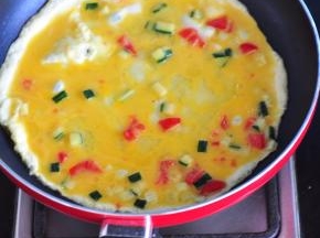 饼熟后倒出，锅里倒入油，倒入蛋液，摊成饼状。