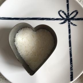 慕斯模具内抹一点点玉米油防粘，先舀一点米饭，压平