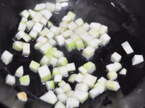 锅里倒入油，放入蒜炸香，放入西葫芦丁翻炒。
