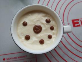 将巧克力酱挤到淡奶油上，可以挤成圆形，也可以直接挤成心形。因为淡奶油和咖啡都是冷的，所以巧克力酱挤上之后就凝固了