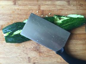 2.去掉头尾，用刀背使劲拍整根黄瓜，拍出瓜瓤，就像对待你的仇人一样使劲拍，哈哈；