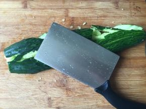 2.去掉头尾，用刀背使劲拍整根黄瓜，拍出瓜瓤，就像对待你的仇人一样使劲拍，哈哈；