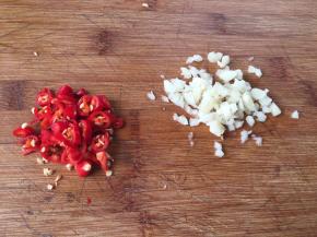 5.小米椒切碎粒，蒜瓣用刀背拍扁再切成碎粒；