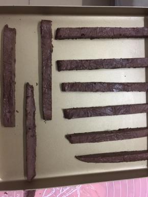 面团变硬后，切成大小均匀的长条，摆放上烤盘，中间留些空隙，烤箱预热上下火170度，上层烤15分钟，再移至中层烤10分钟即可