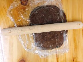 将保鲜膜对折包住面团，用擀面杖擀成长方形