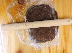 将保鲜膜对折包住面团，用擀面杖擀成长方形