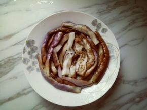 把蒸熟的茄子摆放在盘子里。