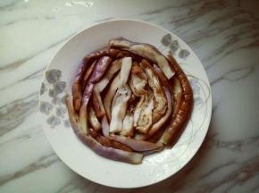 把蒸熟的茄子摆放在盘子里。