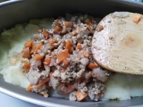 倒入装有土豆泥的学厨蛋糕模具中铺平，也可以戴上手套将其与土豆泥抓匀后铺平