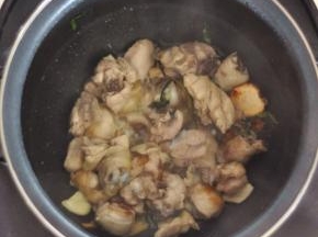 放入飞过水的鸡块，合上盖子，让油将鸡肉两面煎变色。这期间可以去忙别的菜，中途搅拌一下就好。电饭煲火力小，不用担心会糊。