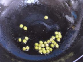 锅里倒入油，放入豌豆。