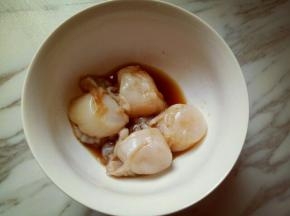 取一个碗，将洗干净的扇贝肉放入碗里，加料酒，生抽，盐，