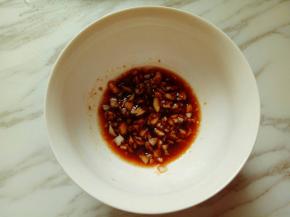 将蒜末装入碗中，加生抽，哪有，少许料酒调汁。