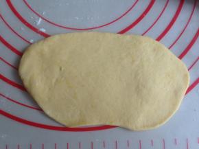 擀成长度13CM左右的椭圆形，其中一条长边向下擀薄一点