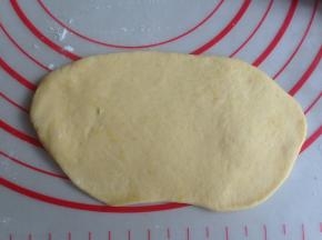 擀成长度13CM左右的椭圆形，其中一条长边向下擀薄一点