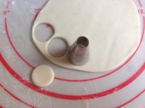 白色面团擀薄，用圆形裱花嘴压出16块圆形