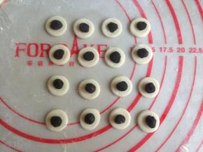 黑色面团揪出一点点，搓圆放在白色面片上