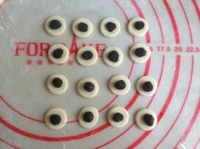 黑色面团揪出一点点，搓圆放在白色面片上