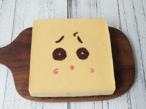 取出凝固的慕斯蛋糕，用热毛巾捂住4周脱模。在表面用巧克力画出表情。