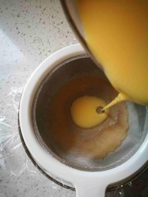 拿一个碗，铺入保鲜膜，然后拿筛子过滤鸡蛋豆浆液倒入碗中