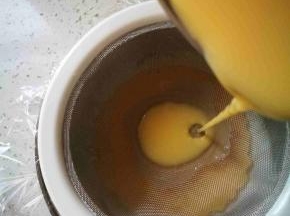 拿一个碗，铺入保鲜膜，然后拿筛子过滤鸡蛋豆浆液倒入碗中