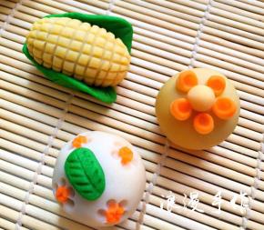 玉米-绿茶桃山皮做玉米的叶子，用牙签压出纹路，黄金桃山皮包好馅后捏成椭圆形，再用牙签压出小格子，用少许水沾好。也可以沾好叶子后再压纹路。剩下两个圆果子是沾上胡萝卜小圆片后用筷子在周围压5个圓印，再沾上一片叶子