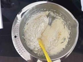 刮刀从2点钟方向插入，刮至8点钟方向，舀起一大勺黄油，移至盆中央，甩掉黄油，左手将盆逆时针转动一下。