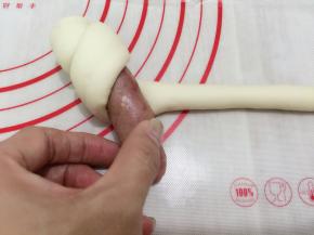 13. 把香肠放在头部开始卷起，一直卷到香肠包住了，尾部收口处也要捏紧