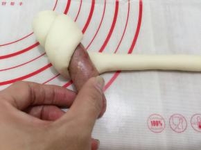 13. 把香肠放在头部开始卷起，一直卷到香肠包住了，尾部收口处也要捏紧