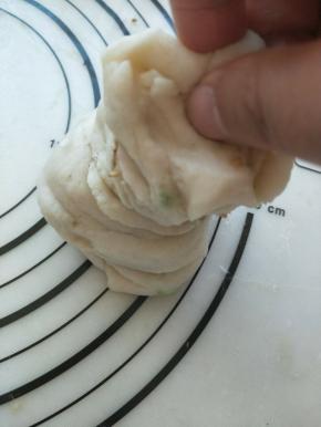 卷好的面团竖起来，在往下压下去，压成一个圆饼。