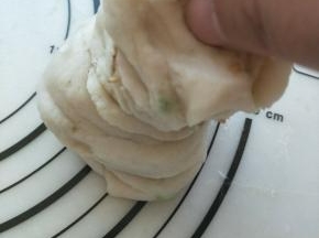 卷好的面团竖起来，在往下压下去，压成一个圆饼。