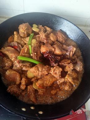 下入葱、姜、八角、干辣椒翻炒，调入老抽，翻炒均匀上色