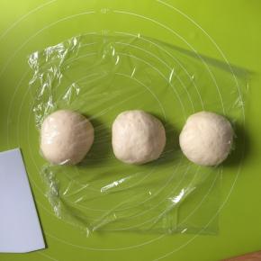 卷起擀扁的面团，平均分为3份，揉圆盖上保鲜膜松弛15分钟