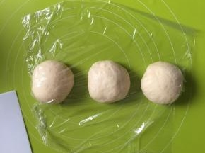 卷起擀扁的面团，平均分为3份，揉圆盖上保鲜膜松弛15分钟