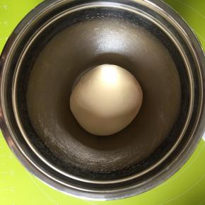 把面团滚圆，放入盆内，盖上湿毛巾保持湿度，进行第一次发酵