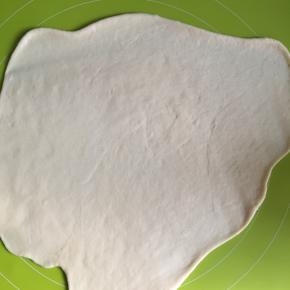 取出发酵好的面团用擀面杖擀扁排出气体