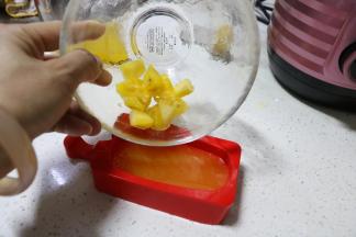 将做好的凤梨汁倒入棒冰模具中，加入凤梨丁