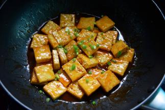 大火将汁收稠后，撒上葱花、芝麻，关火