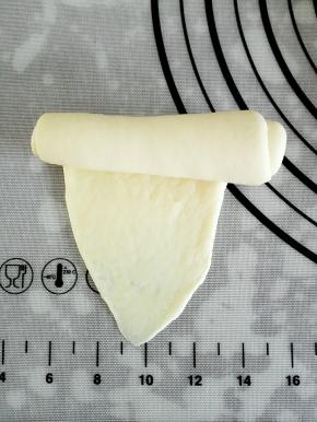 翻面后把底边压薄，由上往下卷起